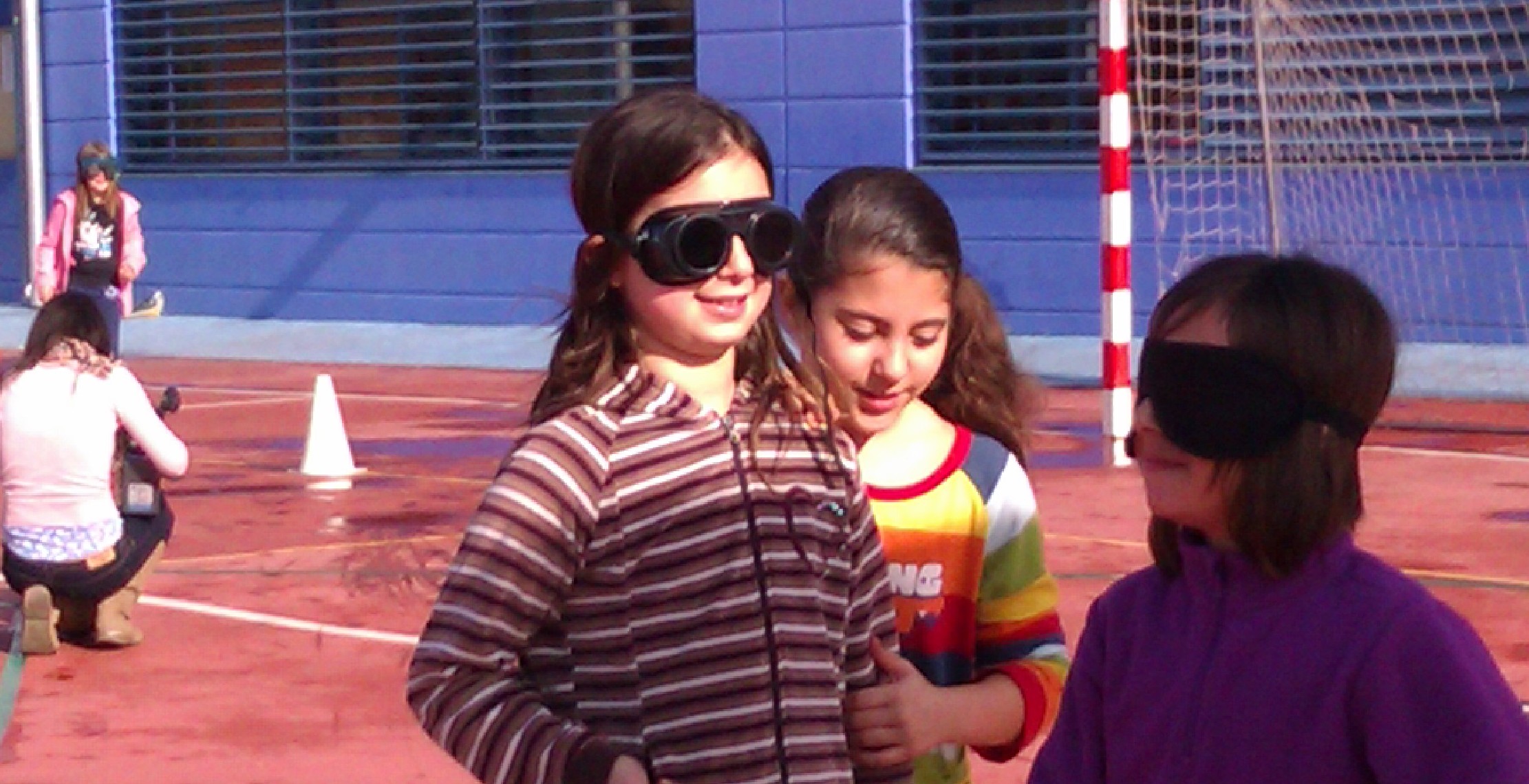 Una niña ayuda a otra que simula tener una cegera